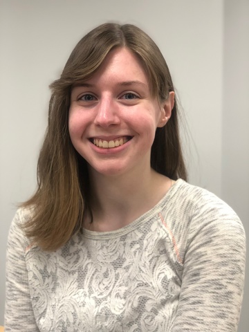 Photo of a person named Allison with shoulder length brown hair who is smiling at the camera. Allison is wearing a long-sleeved cream colored shirt.